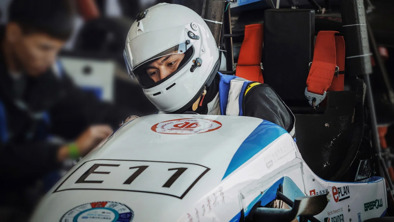 Person med racerhjelm sidder i racerbil