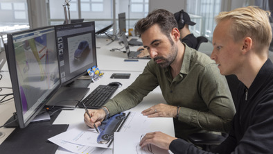 To mænd kigger på tegninger af NIO bil på NIO kontor
