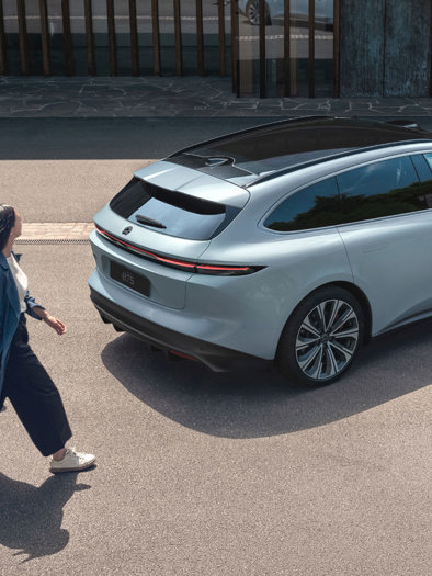 kvinde og mand går mod NIO ET5 Touring med bagage